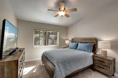 a bedroom with a bed and a ceiling fan at Meadow Chalet townhouse in South Lake Tahoe