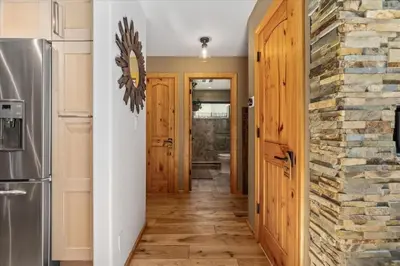 a hallway with wooden floors and a stone wall at Cozy Cabin and Modern Stay in Arnold Near Bear Valley in Arnold