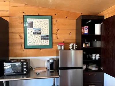 a kitchen with a refrigerator and a map on the wall at Cozy Rustic Cabin on a Working Horse Ranch for a Unique Getaway in Granite Bay, California in Granite Bay