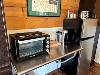 a microwave sitting on a counter next to a refrigerator at Cozy Rustic Cabin on a Working Horse Ranch for a Unique Getaway in Granite Bay, California in Granite Bay