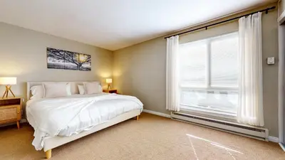 a bedroom with a bed and a large window at Western Slopes Villas #7 condo in Mammoth Lakes