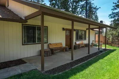 a covered patio with a bench and a table at Blue Bird Ranch in Oakhurst