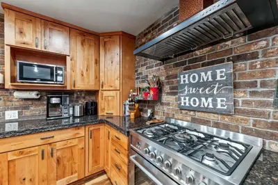 a kitchen with a stove and a brick wall at Tahoe Cabin - Hot Tub, Fire Pit, Pool Table, minutes from Heavenly in South Lake Tahoe