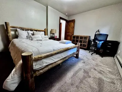a bedroom with a large bed and a chair at Tahoe Cabin - Hot Tub, Fire Pit, Pool Table, minutes from Heavenly in South Lake Tahoe