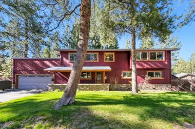 a red house with trees in front of it at Tahoe Cabin - Hot Tub, Fire Pit, Pool Table, minutes from Heavenly in South Lake Tahoe