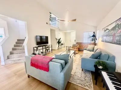 a living room with two couches and a piano at Tranquil Getaway in Fresno