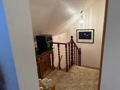 a hallway with a staircase with a microwave on a table at Gold Country Serenity! 45 Minutes to Powder! in Grass Valley