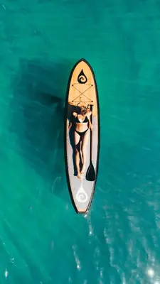 a woman on a paddle board in the water at Lakeside Condo Close to Slopes Excellent Location in Tahoe Vista