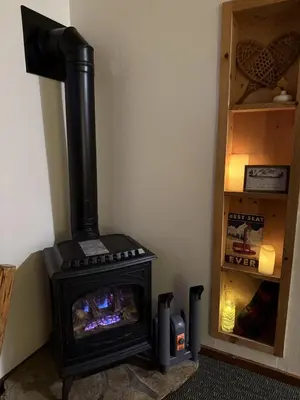 a black stove sitting in a corner next to a shelf at Lakeside Condo Close to Slopes Excellent Location in Tahoe Vista