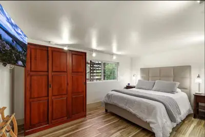 a bedroom with a large bed and a wooden cabinet at Hot TubSaunaPoolPrivate Beach Tahoe Oasis in Zephyr Cove