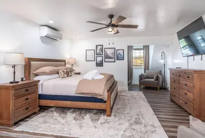 a bedroom with a bed and a ceiling fan at The Four Daughters Inn in Oakhurst