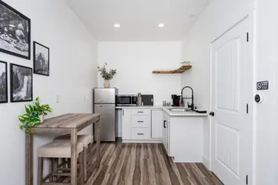 a kitchen with a table and a refrigerator at The Four Daughters Inn in Oakhurst