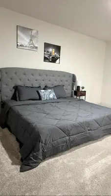 a bedroom with a large bed with a gray bedspread at New Holiday Retreat in Merced in Merced