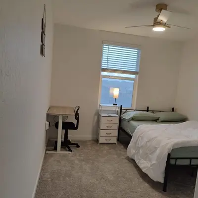 a bedroom with two beds and a desk and a window at The Orchid house !! Your home away from home Gateway to Yosemite & UC Merced this for a Room in Merced