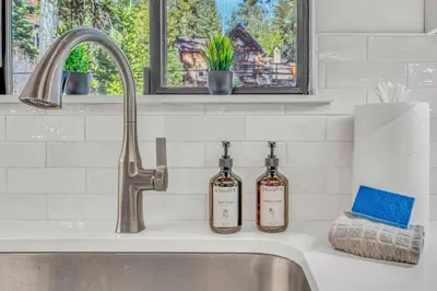 two bottles of wine sitting on a kitchen sink at Cozy Cabin- Large Deck , Near the Slopes in Homewood