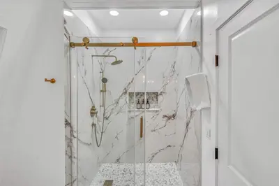 a bathroom with a shower with marble walls at Cozy Cabin- Large Deck , Near the Slopes in Homewood