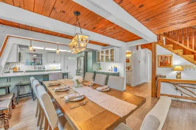 a dining room with a table and a kitchen at Cozy Cabin- Large Deck , Near the Slopes in Homewood