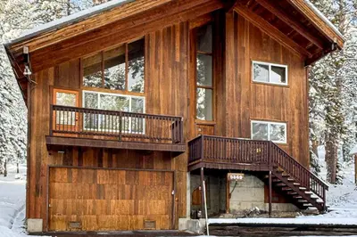 a log cabin in the snow with a balcony at Tahoe Alpine and Lake Escape in Carnelian Bay