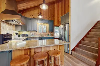 a kitchen with wooden cabinets and a counter with stools at Tahoe Alpine and Lake Escape in Carnelian Bay
