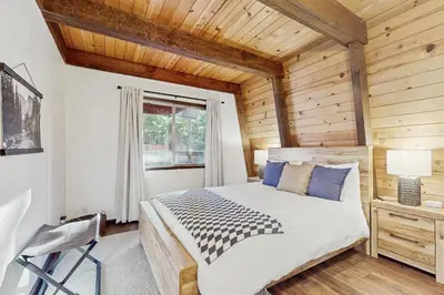 a bedroom with a large bed and a wooden ceiling at Charming Cabin in South Lake Tahoe