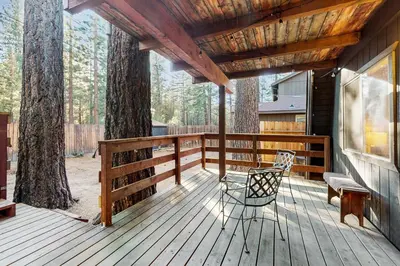 a wooden deck with a chair and a bench on it at Charming Cabin in South Lake Tahoe