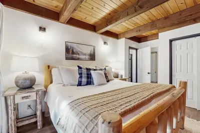 a bedroom with a large bed and a wooden ceiling at Charming Cabin in South Lake Tahoe