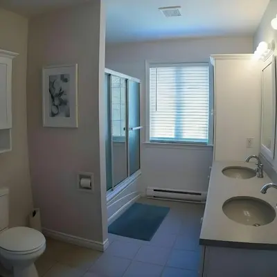 a bathroom with two sinks and a toilet and a window at PINECREST MAMMOTH LAKES in Mammoth Lakes