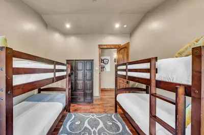 a room with three bunk beds and a hallway at South Lake Tahoe Escape - Private Hot Tub Pool in South Lake Tahoe