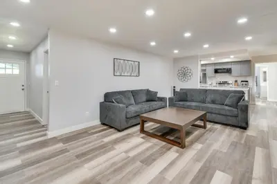 a living room with two couches and a table at 2 Mi to UC Merced Modern Home with Private Yard in Merced