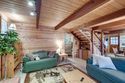 a living room with wooden walls and blue couches at 3 Mi to Calaveras Big Trees Group-Ready Mtn Cabin in Arnold