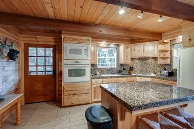 a kitchen with wooden cabinets and white appliances at 3 Mi to Calaveras Big Trees Group-Ready Mtn Cabin in Arnold