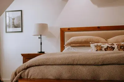 a bedroom with a bed and a lamp on a table at Kinslee Suite at The Four Daughters Inn in Oakhurst