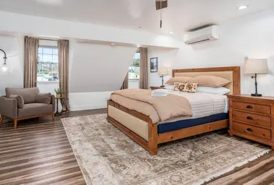 a bedroom with a large bed and a chair at Peytons Luxury Suite at The Four Daughters Inn in Oakhurst