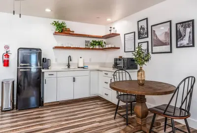 a kitchen with a table and a refrigerator at Peytons Luxury Suite at The Four Daughters Inn in Oakhurst