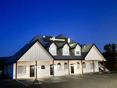 a large white building with a black roof at Peytons Luxury Suite at The Four Daughters Inn in Oakhurst