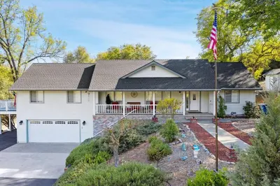 a white house with an american flag at Harmony Home- EV Charger in Oakhurst