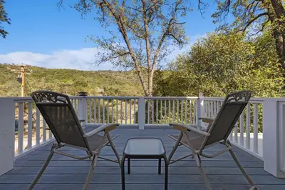 two chairs sitting on the deck of a house at Harmony Home- EV Charger in Oakhurst