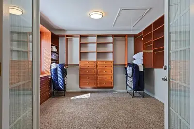 a walk in closet with wooden cabinets and shelves at Harmony Home- EV Charger in Oakhurst