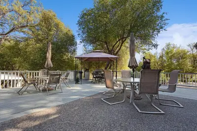 a patio with tables and chairs and an umbrella at Harmony Home- EV Charger in Oakhurst