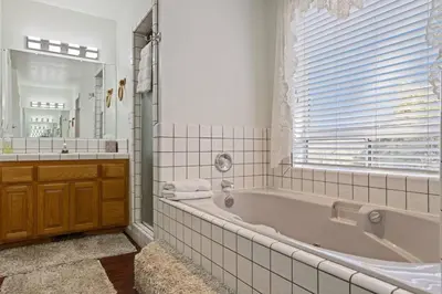 a white bathroom with a tub and a window at Harmony Home- EV Charger in Oakhurst
