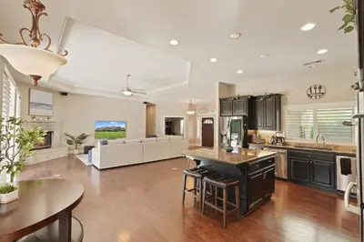 an open kitchen and living room with a table and chairs at Oasis on the vine - Custom Luxury Resort Amenities in Lodi