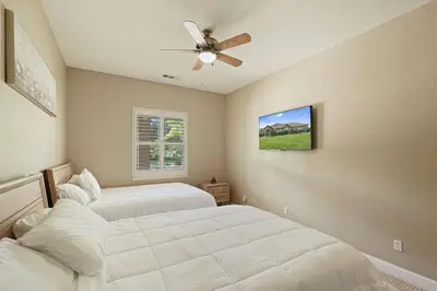 a bedroom with two beds and a ceiling fan at Oasis on the vine - Custom Luxury Resort Amenities in Lodi