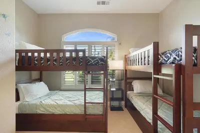 two bunk beds in a room with a window at Oasis on the vine - Custom Luxury Resort Amenities in Lodi
