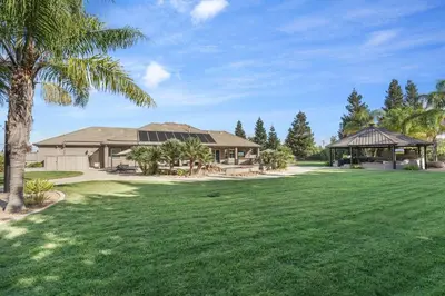 a house with a palm tree and a gazebo at Oasis on the vine - Custom Luxury Resort Amenities in Lodi