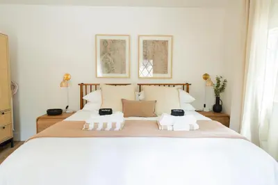 a bedroom with a large white bed with two glasses on it at Rare Stay Inside Yosemite NP w Hot Tub, AC, WiFi in Wawona