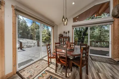 a dining room with a table and chairs and a large window at Multi-Family Villa-private spa waterfall in Shaver Lake