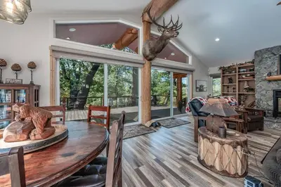 a living room with a wooden table and a large window at Multi-Family Villa-private spa waterfall in Shaver Lake