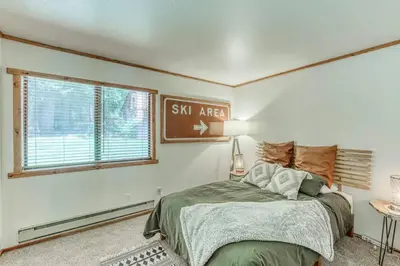 a bedroom with a bed and a sign on the wall at Little Ski Lodge-Across from Spa & Sauna in Shaver Lake