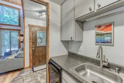 a kitchen with a sink and a couch in a room at Little Ski Lodge-Across from Spa & Sauna in Shaver Lake
