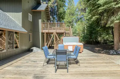 a patio with a table and chairs on a deck at Lazy Bear Lodge Rustic Luxe Villa with spa & gameroom in Shaver Lake